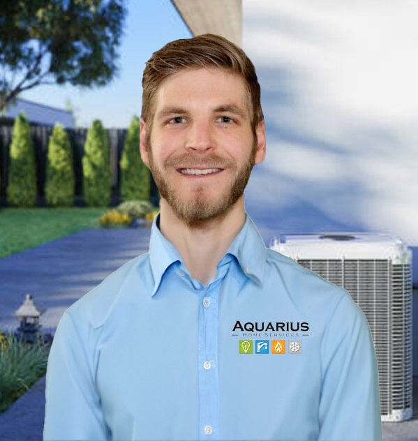 A smiling man in a light blue shirt with the Aquarius Home Services logo stands outdoors, exuding warmth and reliability. Behind him, trees frame a lush lawn and an air conditioning unit, set against the backdrop of a modern home exterior that highlights their expert touch.