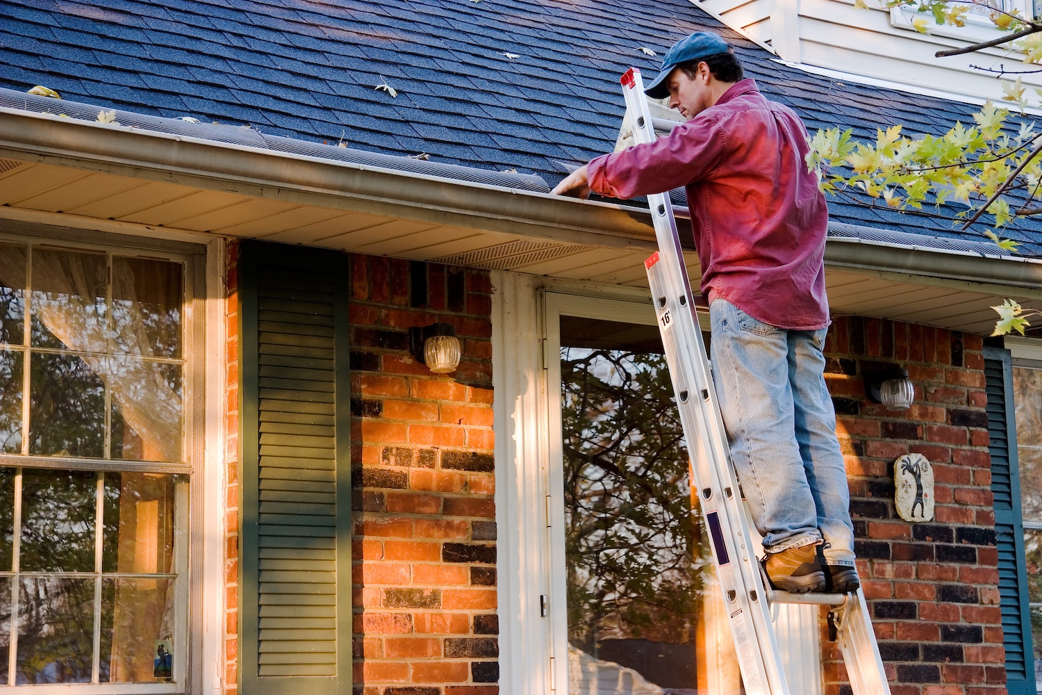 new roofing contractor Cleaning Gutters on Ladder