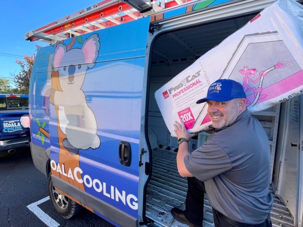A technician in a blue cap carries insulation material beside a KOALA COOLING van, branded with a cartoon koala. Get ready for 2025 HVAC bids with our comprehensive HVAC Pricing Guide—your trusted resource for accurate, up-to-date pricing and dependable service.