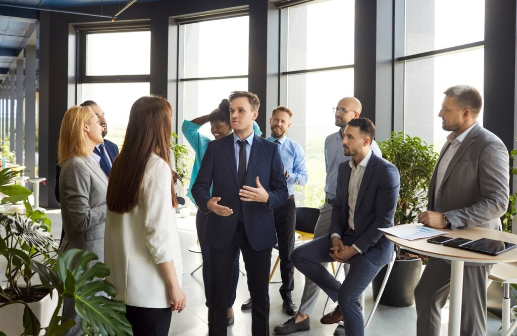 Hook Agency’s team discusses lead generation strategies in a modern office, sharing actionable insights and engaging together.