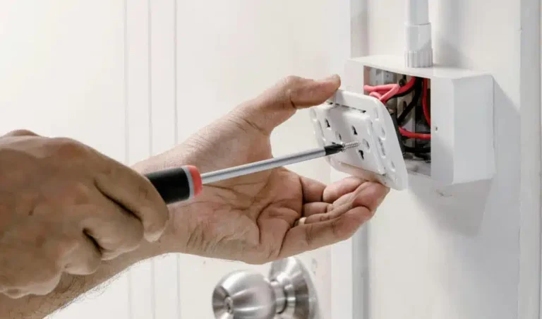 Professional electrician unscrews an outlet cover with precision, showcasing the skill and focus electricians bring to every job, just like a tailored marketing strategy from a top electrician marketing agency