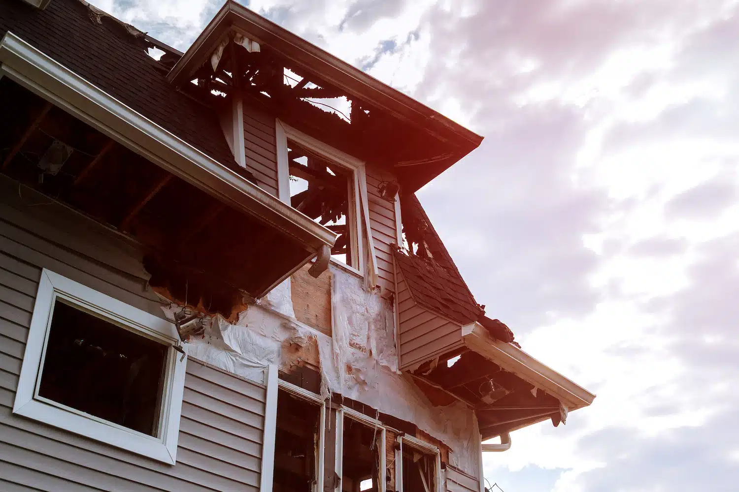 On Hook Agency's website, an image of a fire-damaged house with charred and missing roof sections, broken windows, and burned siding is strikingly set against a partly cloudy sky. This powerful visual metaphor highlights our commitment to crafting impactful website designs.