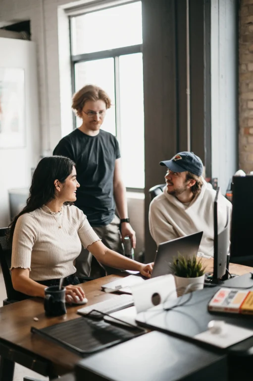 In a casual office setting at Hook Agency, three team members focus intently on SEO strategy.